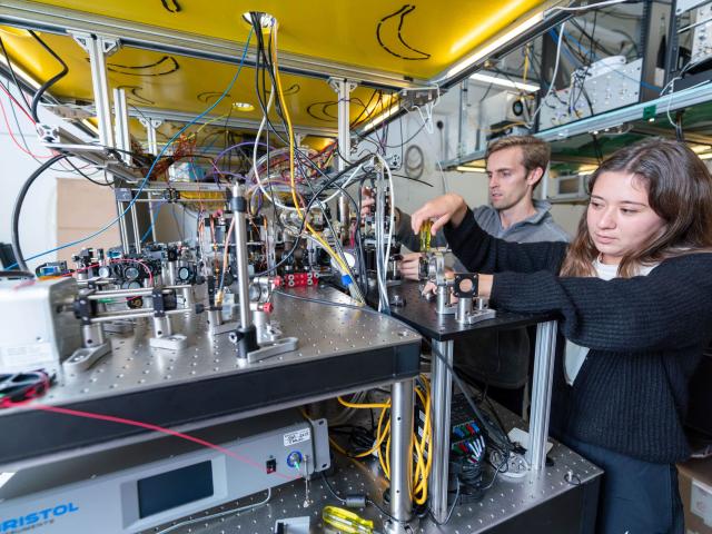 students working on physics machine