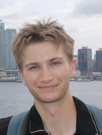smiling student in front of buildings